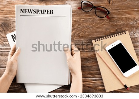 Woman with newspapers on wooden background