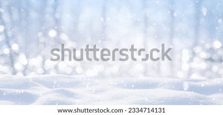 Festive Christmas natural snowy background, abstract empty stage, snow, snowdrift and defocused Christmas lights in forest on light blue background, copy space.