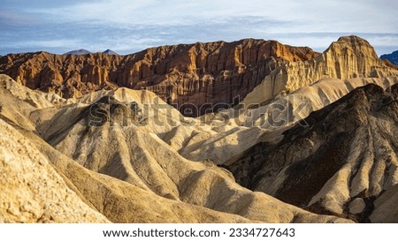 panorama of the mountains in golden canyon during the spring sunrise; the famous coloured mountains which can be seen from zabriskie point; hiking in golden canyon in death valley national park	 Royalty-Free Stock Photo #2334727643
