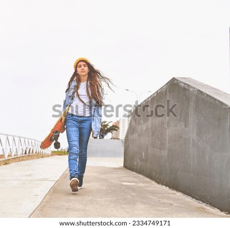 Girl having fun riding skateboards at skate park, Portrait of smiling young female skateboarder holding her skateboard. Recreational Activity Concept.