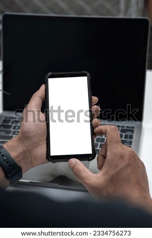 Man holding smartphone with blank screen, close-up of hands. Space for text.