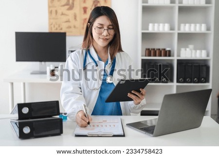 Female doctor working on desk with tablet, laptop computer and paperwork in the office. Medical and doctor concept.