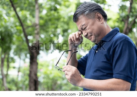 Senior Asian Man holding unfit glasses, Struggling with Eyesight Problem, Eye Health Concept Royalty-Free Stock Photo #2334790251