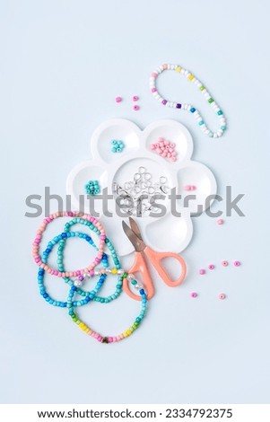 Children's needlework and beading. Handmade bracelets and different beads for children's crafts. DIY art activity for kids. Motor skills, creativity and hobby. Royalty-Free Stock Photo #2334792375