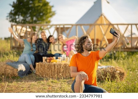 Happy group of friends multiracial Very charismatic taking selfies with smartphone hugging all each other and sitting down on the haystack