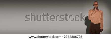 real people, bold african american man with myasthenia gravis syndrome standing with walking cane on grey background, dark skinned person in shirt, diversity and inclusion, looking at camera, banner