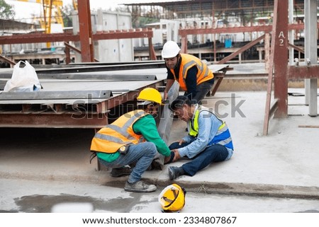 First Aid and safety first concept. Professional engineering teamwork concept. Engineering supervisor helping his coworker lying unconscious at industrial factory. Professional engineering teamwork  Royalty-Free Stock Photo #2334807867