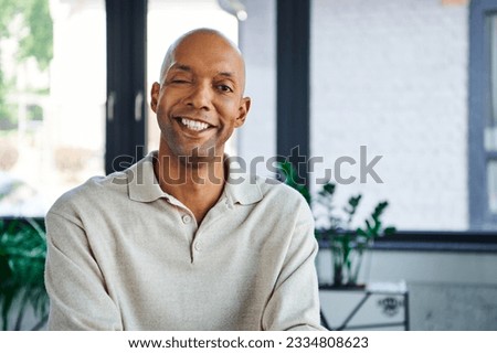 professional headshots, cheerful dark skinned man with myasthenia gravis disease looking at camera, happy office worker with eye syndrome, inclusion and diversity Royalty-Free Stock Photo #2334808623