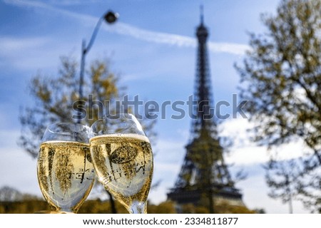 A shallow focus shot of two glasses of champagne against the Eiffel Tower background