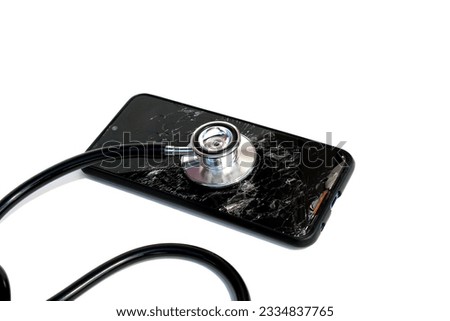 A broken broken phone with a stethoscope lies on a white background.