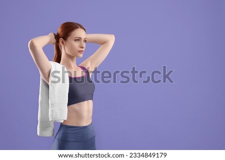 Woman in sportswear with towel on violet background, space for text