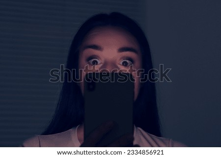 Woman using modern smartphone in dark room. Internet addiction