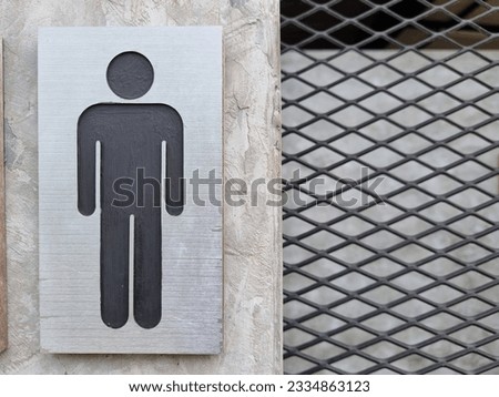 black male and female restroom sign on cement wall