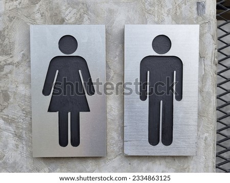 black male and female restroom sign on cement wall