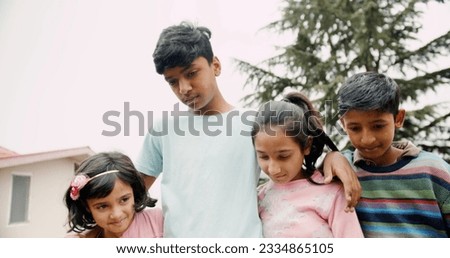 A low angle shot of South Asian kids looking down in the house garden in India Royalty-Free Stock Photo #2334865105