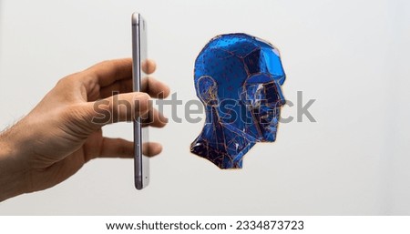 A person holding a phone out toward a 3D rendered artificial holographic human head