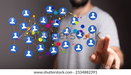A blurred shot of a man pointing at illustrated digital icons of people, concept of networking