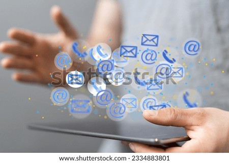 A businessman holding a tablet with 3D rendered holograms of call and email icons floating on the screen