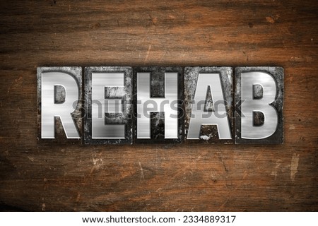The word -Rehab- written in vintage metal letterpress type on an aged wooden background.