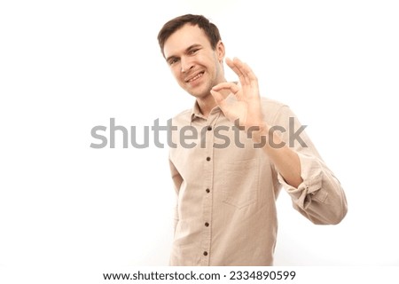 Portrait of young man showing OK sign with fingers isolated on white background. Successful career, approved concept