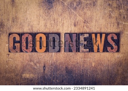 The word -Good News- written in dirty vintage letterpress type on a aged wooden background.