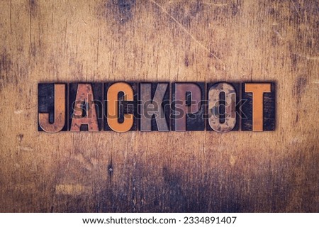 The word -Jackpot- written in dirty vintage letterpress type on a aged wooden background.