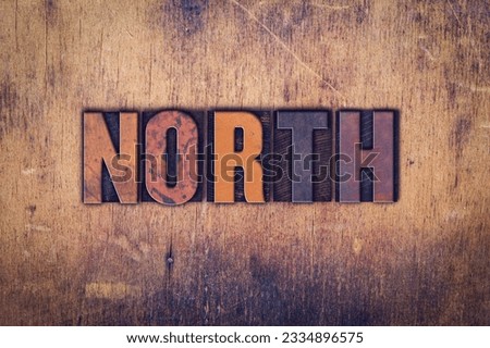 The word -North- written in dirty vintage letterpress type on a aged wooden background.