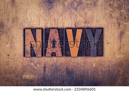 The word -Navy- written in dirty vintage letterpress type on a aged wooden background.