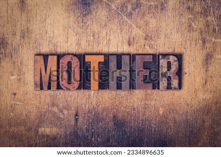 The word -Mother- written in dirty vintage letterpress type on a aged wooden background.
