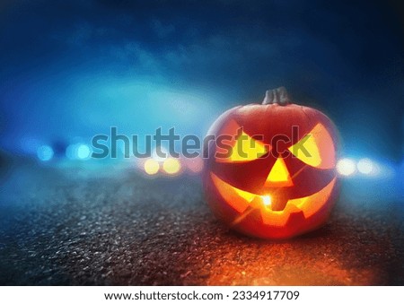 Halloween Night. A Jack O Lantern Pumpkin glowing orange on Halloween evening.
