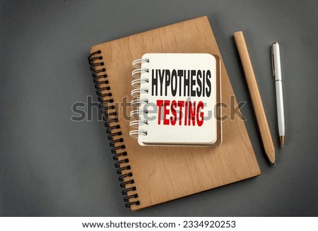 Hypothesis testing text on a notebook with pen and pencil on grey background Royalty-Free Stock Photo #2334920253