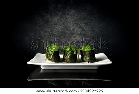 Spicy sushi with seaweed on white plate