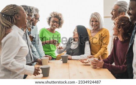 Multigenerational people having fun together inside kitchen while drinking coffee Royalty-Free Stock Photo #2334924487