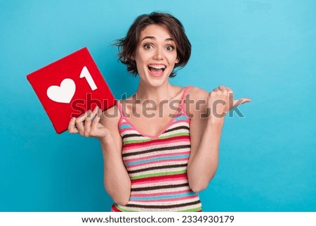 Photo of astonished charming person arm hold like notification direct finger empty space isolated on blue color background