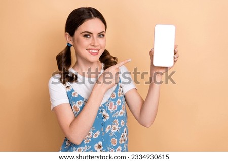Photo of young cheerful girl dress direct finger empty space phone display qr code new restaurant menu isolated on beige color background