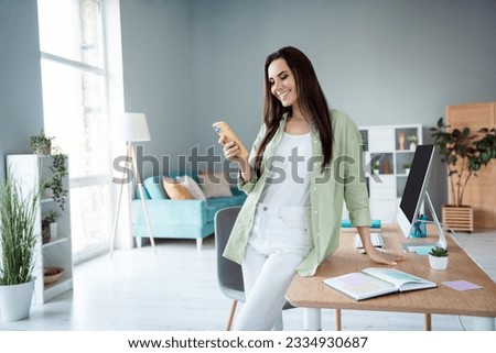 Photo of charming successful girl use iphone read sms writing notes meeting partners answer email indoors workplace