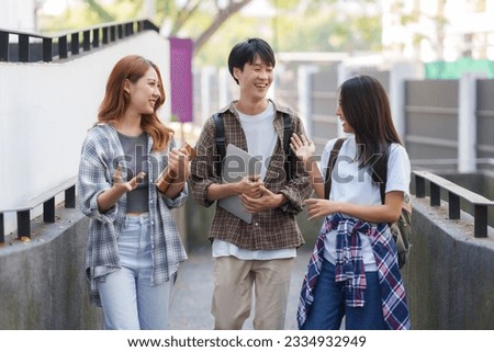 Group Of Young Asian Students Collaborating Outdoors at University. Teamwork and Knowledge Sharing. Asian Students Engaged in Collaborative Learning Outdoors.