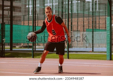 A basketball player plays streetball on a hot day.