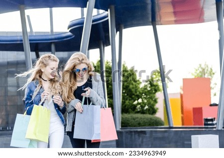 2 two women friends shopping with bags at the mall outdoor
