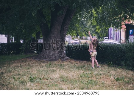Nice little girl is playing in the park. This photo has been taken in Prague, 2023
