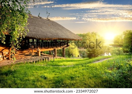 House of log near lake at sunset