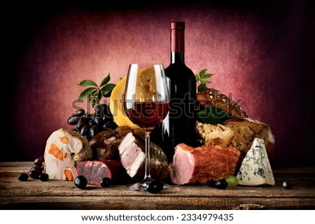 Red wine and different food on a wooden table