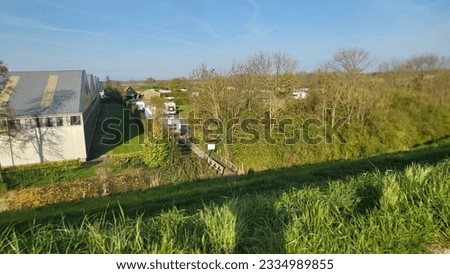 BROUWERSHAFEN, NETHERLANDS - APRIL 27, 2023:
Brouwershafen, The Netherlands - April 27, 2023:
Campers parked on a Camer Van pitch. Concept camper van leisure and fun