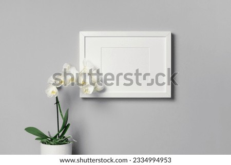 Blank landscape picture frame mockup with white orchid flower, copy space