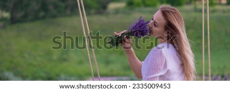 girl on a swing in a field of lavender. Selective focus. Nature