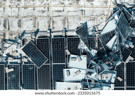 Broken down photovoltaic solar panels destroyed by hurricane Ian winds mounted on industrial building roof for producing green ecological electricity. Consequences of natural disaster Royalty-Free Stock Photo #2335015675