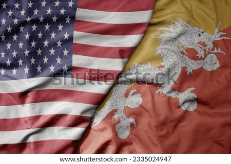 big waving colorful flag of united states of america and national flag of bhutan . macro