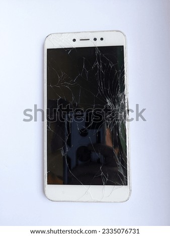 Mobile phone with cracked screen falling from second floor with white background
