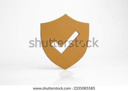 Paper cut of security shield with check mark on white background.