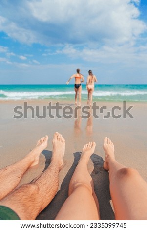 Closeup of the feet of family on the white sandy beach. Children play on the beach in shallow water on summer vacation. High quality photo